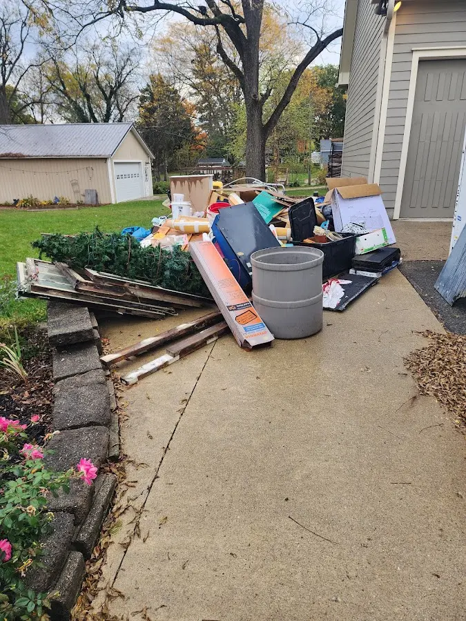 Dumpster being loaded with debris for 12 Yard Dumpster Rental in Grand Rapids